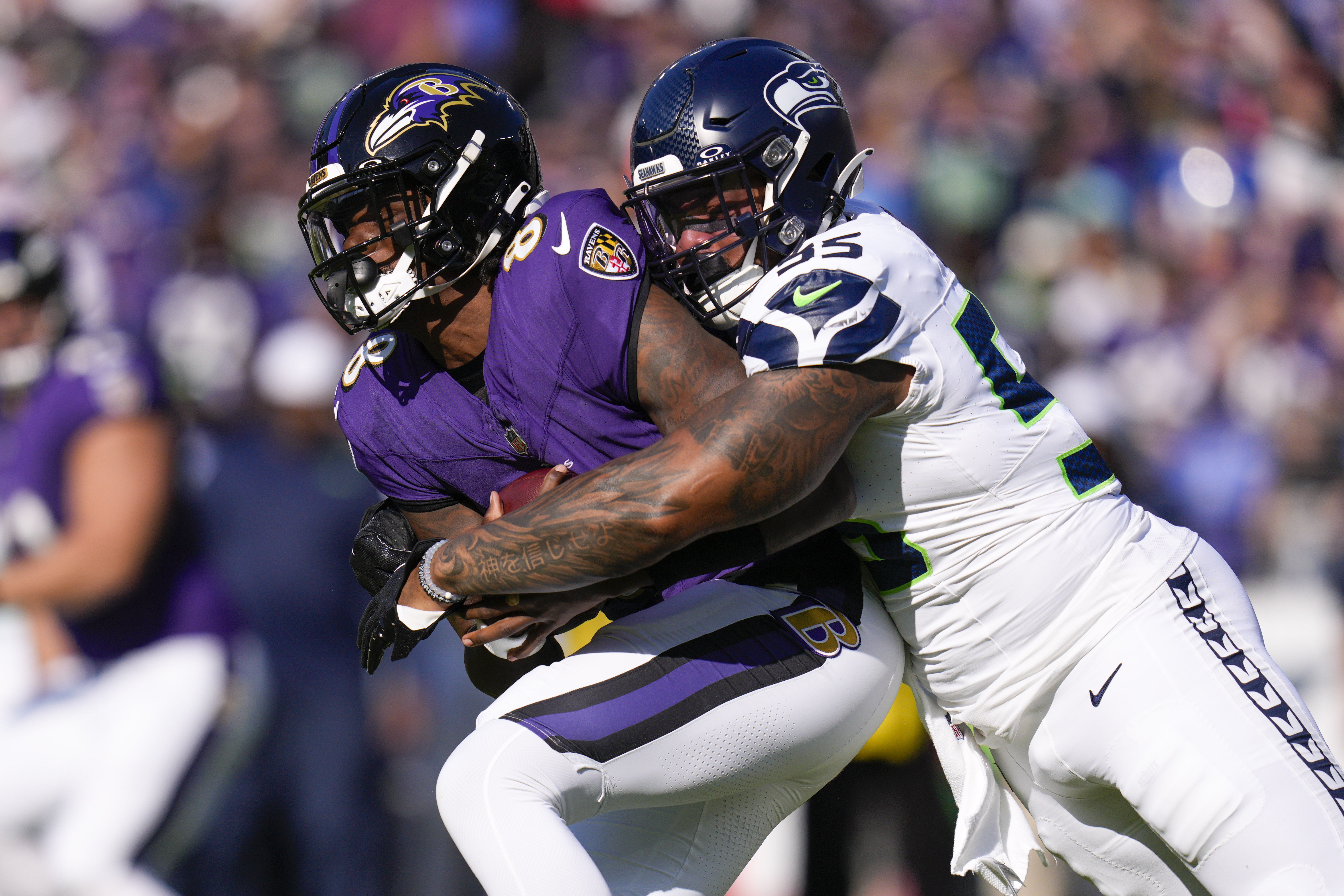Seattle Seahawks defensive end Dre'Mont Jones (55) sacks Baltimore Ravens quarterback Lamar Jackson (8) during the first half at M&T Bank Stadium.